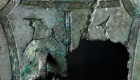 Reverse side of bronze object, with designs of a bird perched in a tree. <br/> Birds were considered to be sacred mediators that linked the heavens and earth, and brought peace and bounty to a village.